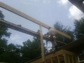 Carpenter setting a ridge beam over a new addition frame — Ice Dam Removal by Roofing Brothers in Poway